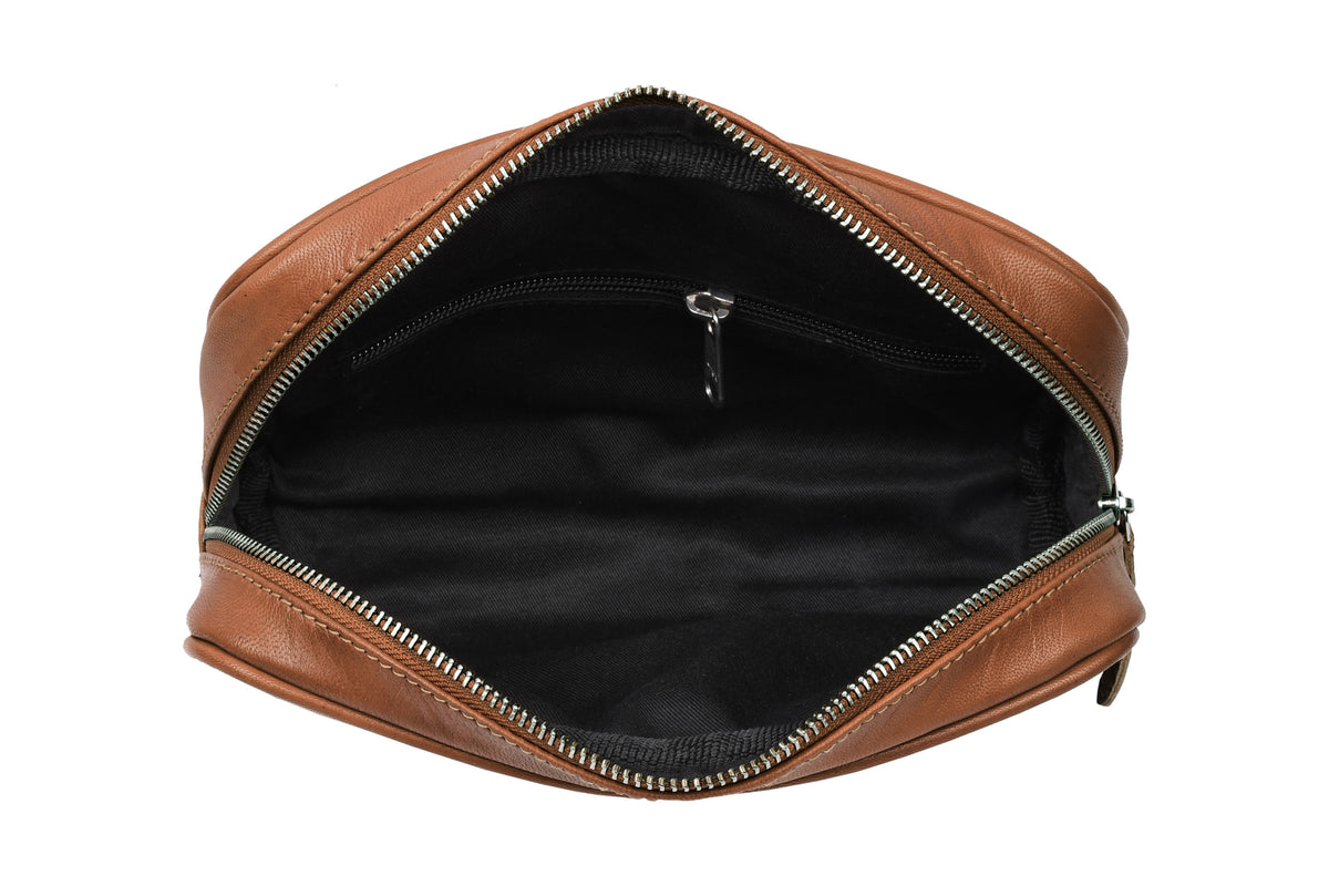 Cognac leather toiletry bag open showing water-resistant polyester twill lining