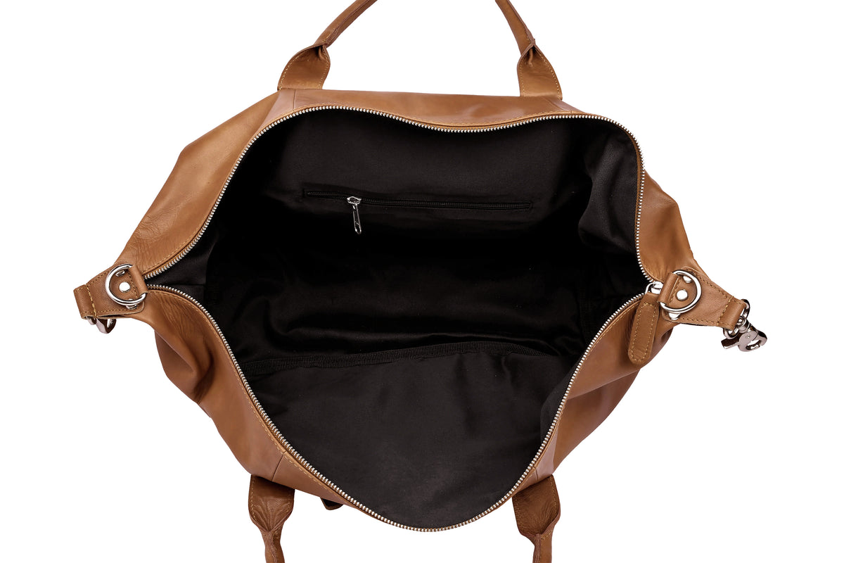 Interior of cognac leather travel bag showing water-resistant polyester lining and zip pocket.