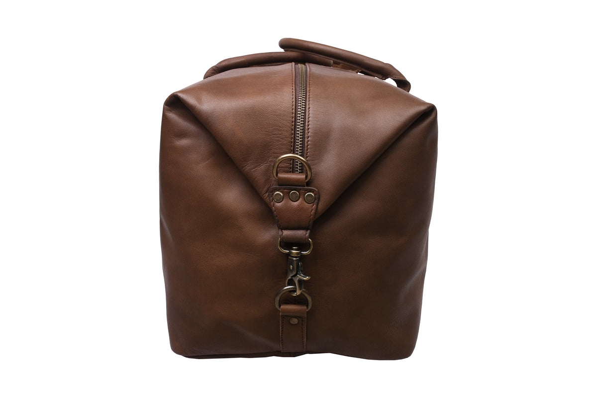 Side view of dark brown full-grain leather travel bag with carabiner end closure.