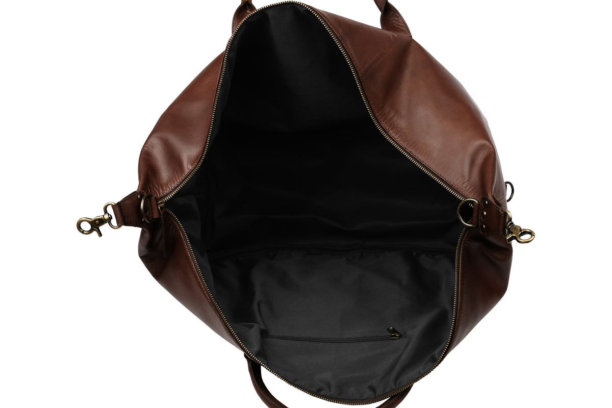 Interior of dark brown leather travel bag showing water-resistant polyester lining
