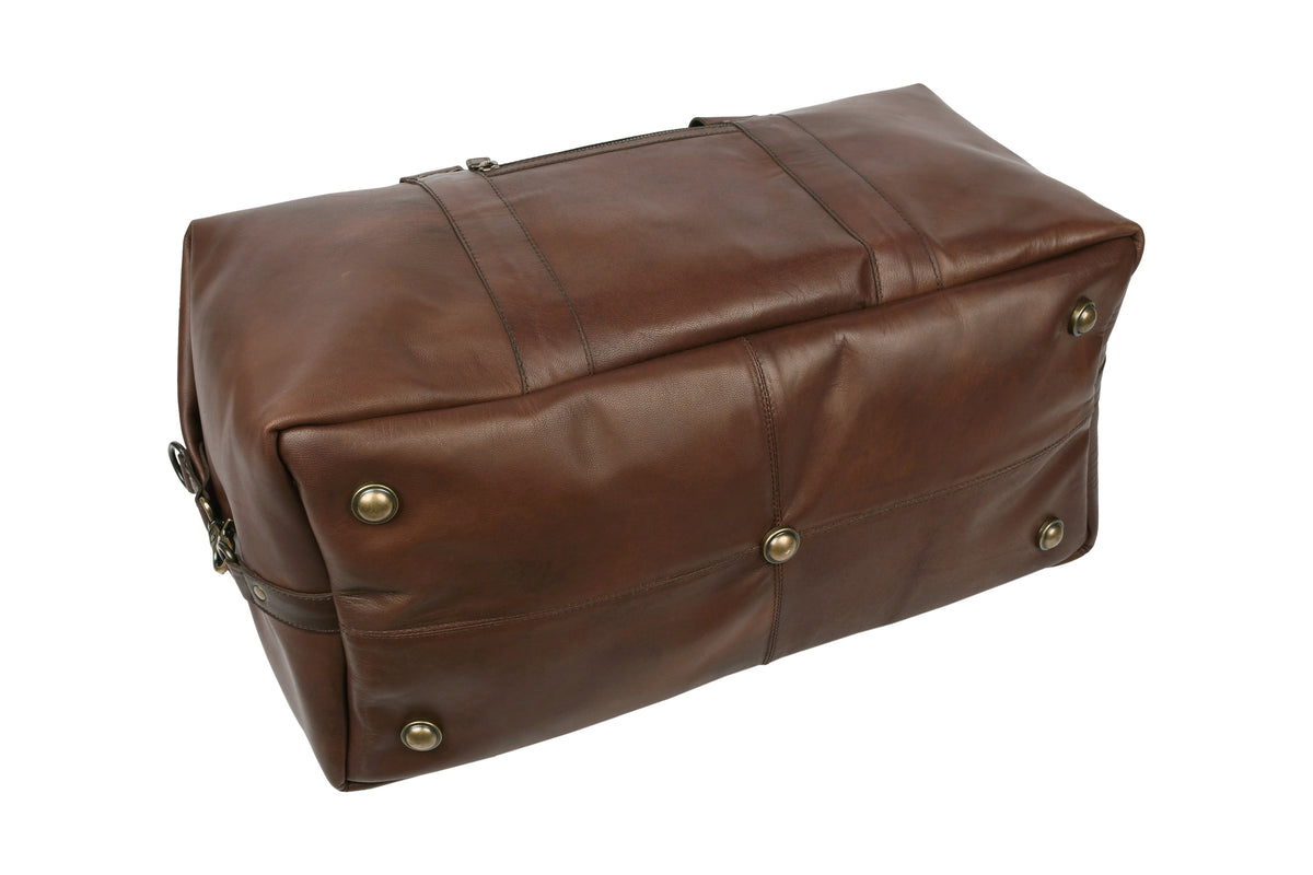 Close-up of bottom studs protecting dark brown leather travel bag on hard surfaces