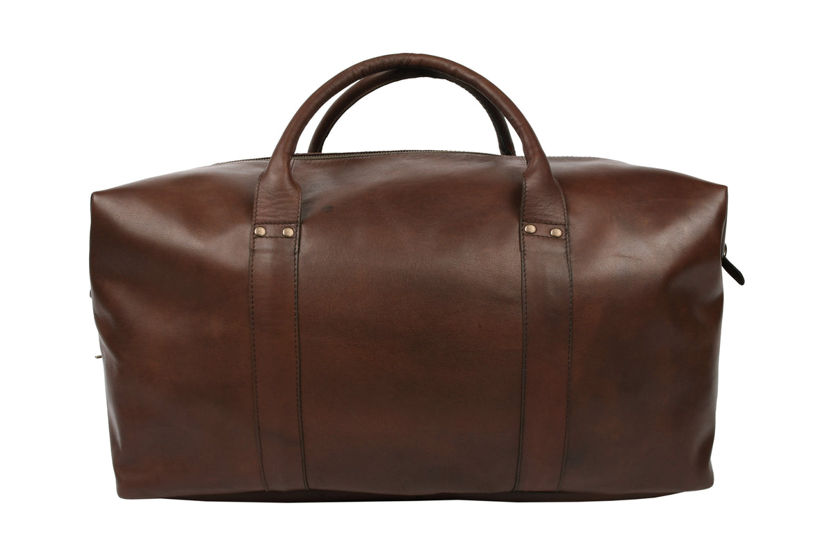 Dark brown leather travel bag styled in use, Scandinavian travel accessory.